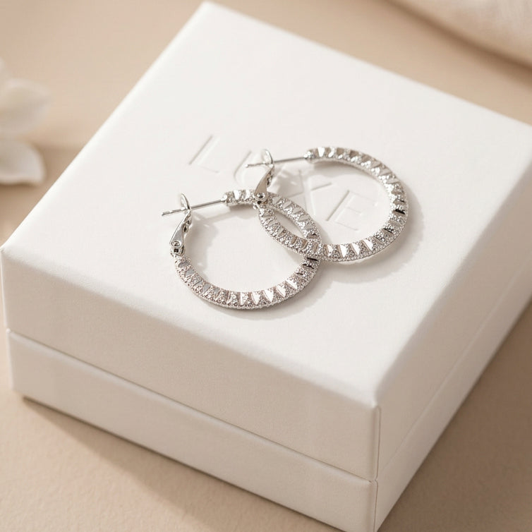 Textured hoop earring by MX featuring a sleek, rounded design with detailed surface texture, worn on an ear.