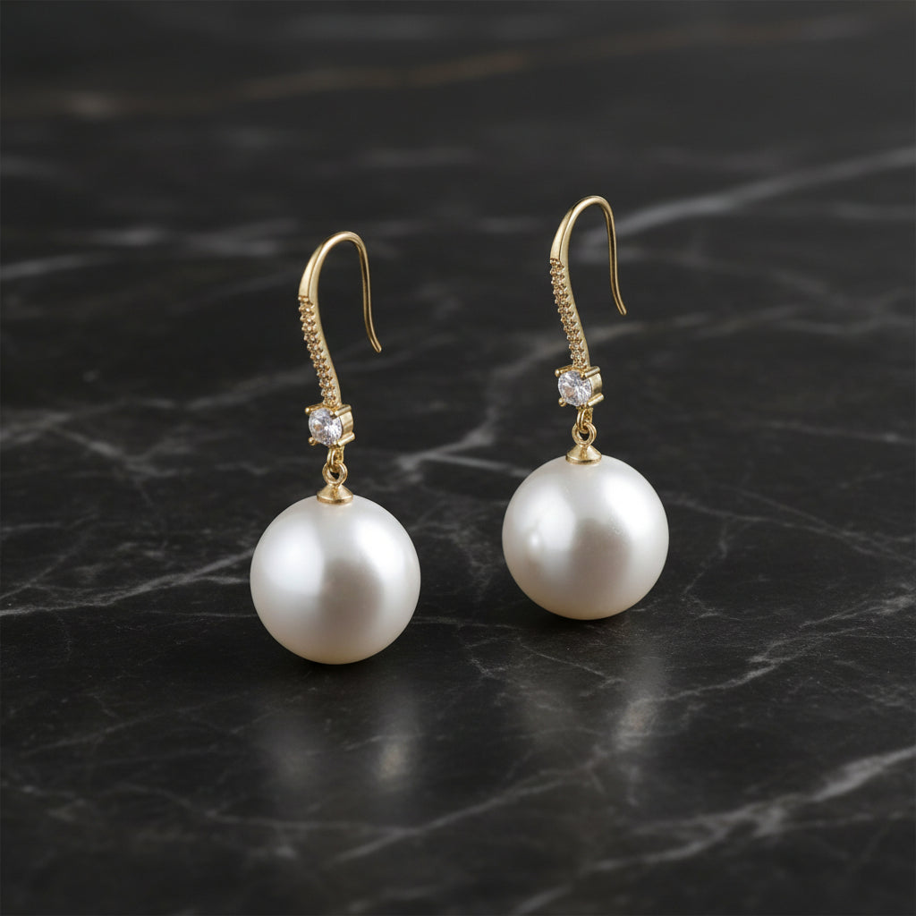 Gold CZ dangle earring with a pearl, stylish jewelry piece from DX Collection, LLC featuring sparkling stones and elegant design.
