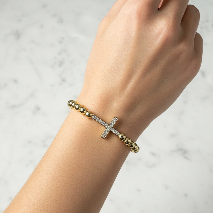 Lorena gold beaded bracelet featuring a CZ cross charm, stylish and elegant jewelry accessory.