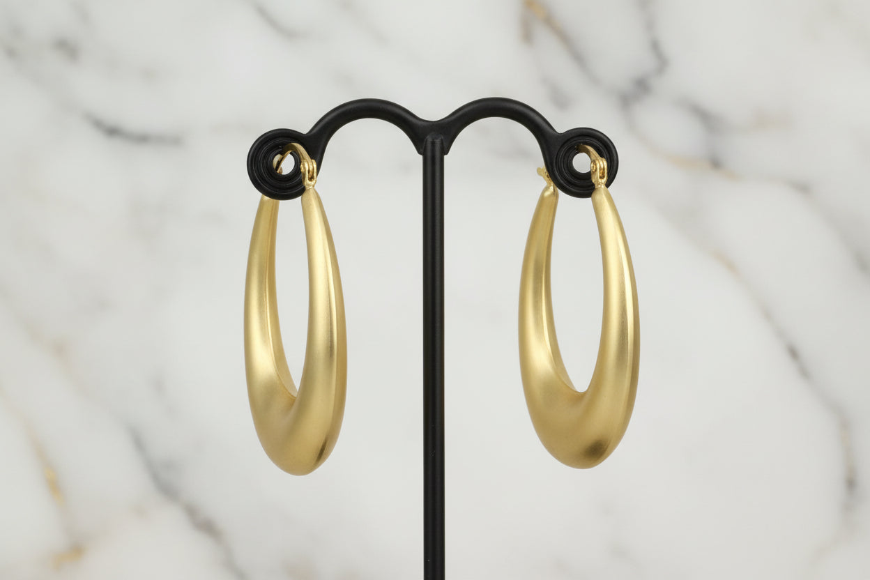 Lorena brushed gold oval hoop earring showcasing a sleek, modern design with a polished finish and secure clasp.