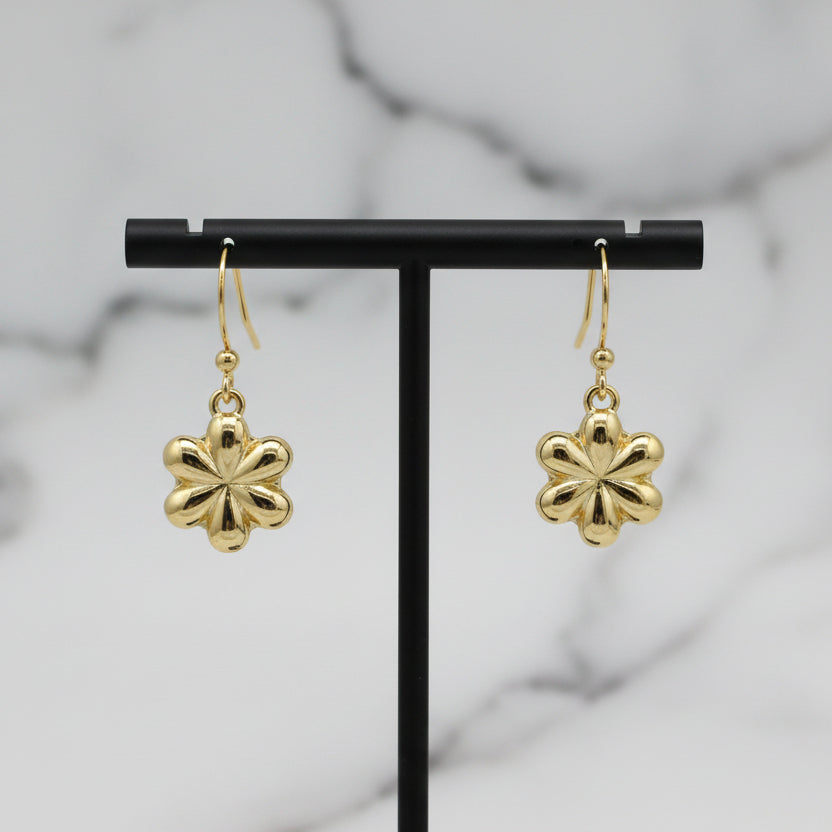 Gold dangle flower earring by Lorena featuring a delicate floral design and shiny gold finish.