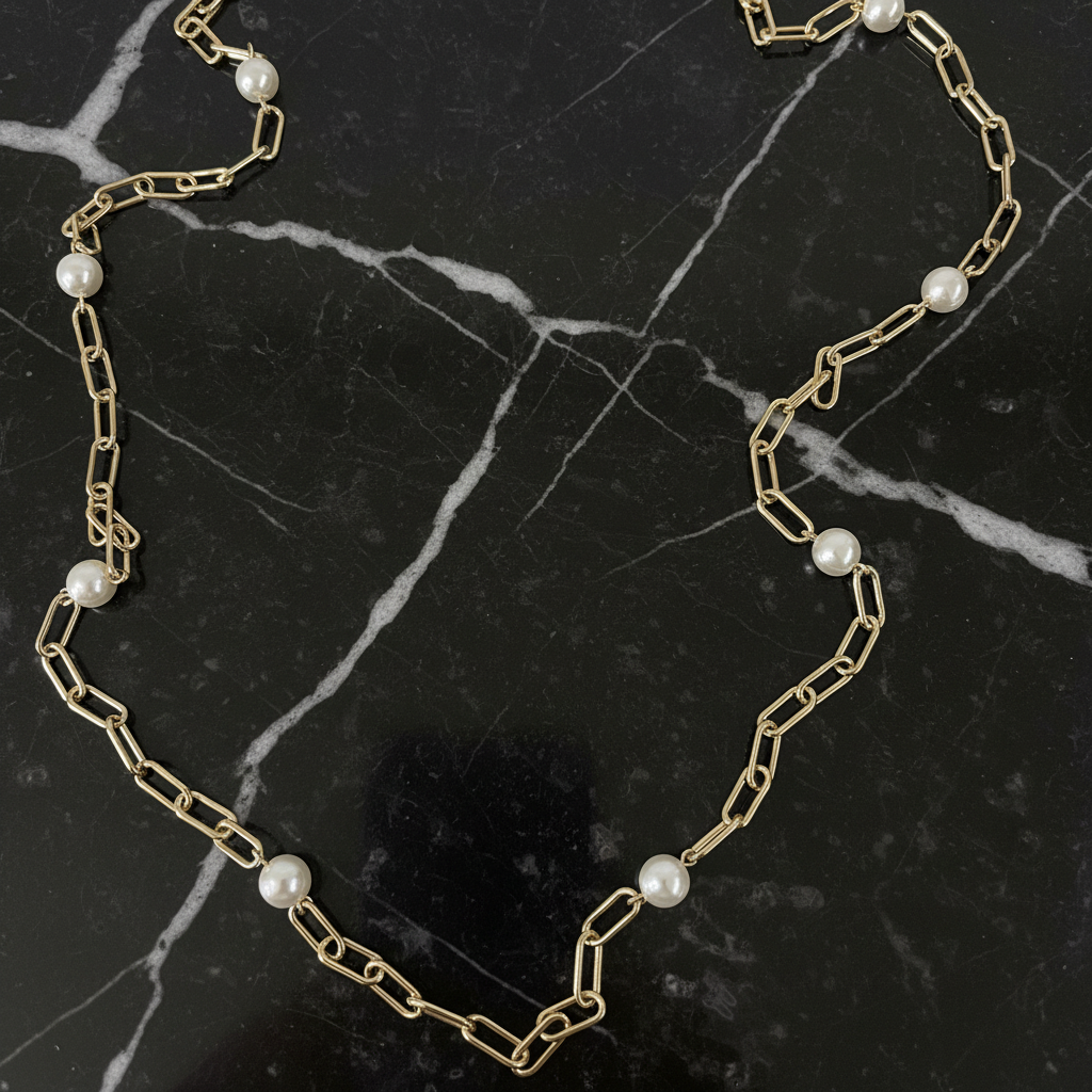 Gold and pearl paper clip necklace by Lorena featuring elegant gold links with pearl accents.