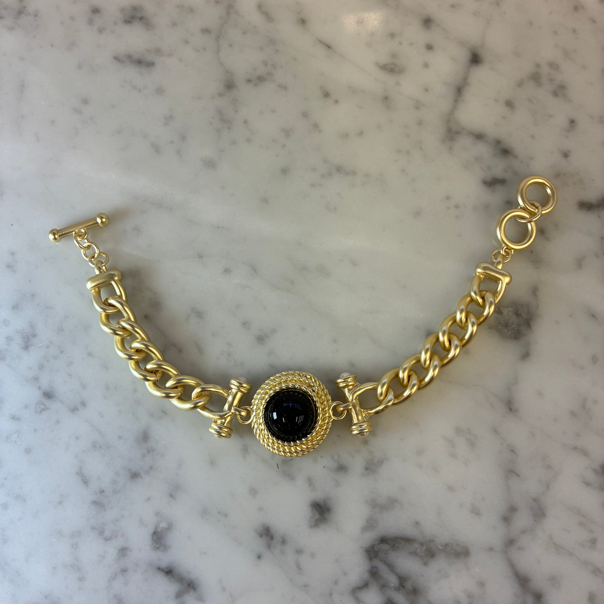 Matte gold MX bracelet with sleek, minimalist design, featuring a smooth finish and subtle shine, suitable for everyday wear.