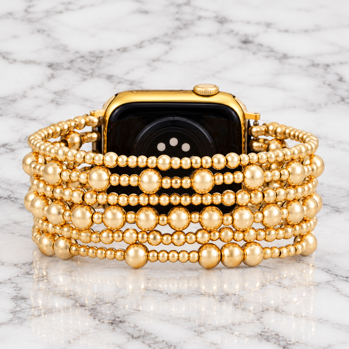 Luxurious gold beaded Demure stretch Apple Watch strap by Cape Diablo on marble background, showcasing elegant watch band design.