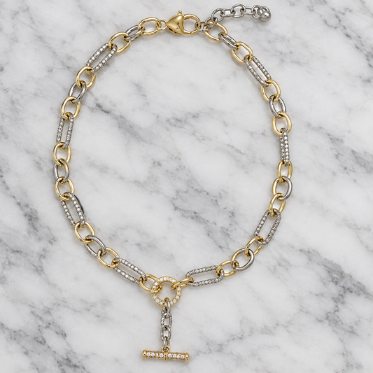 MX two-tone cable link necklace with a dangle T-bar, featuring mixed-metal design on a marble background.