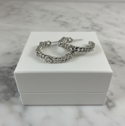 Silver round CZ hoop earring by MX, 1.25 inches in diameter, featuring sparkling cubic zirconia stones and a classic hoop design.