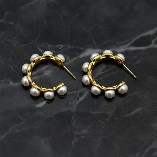 Gold hoop earring with pearls from DX Collection, LLC, featuring a classic circular design with elegant pearl accents.