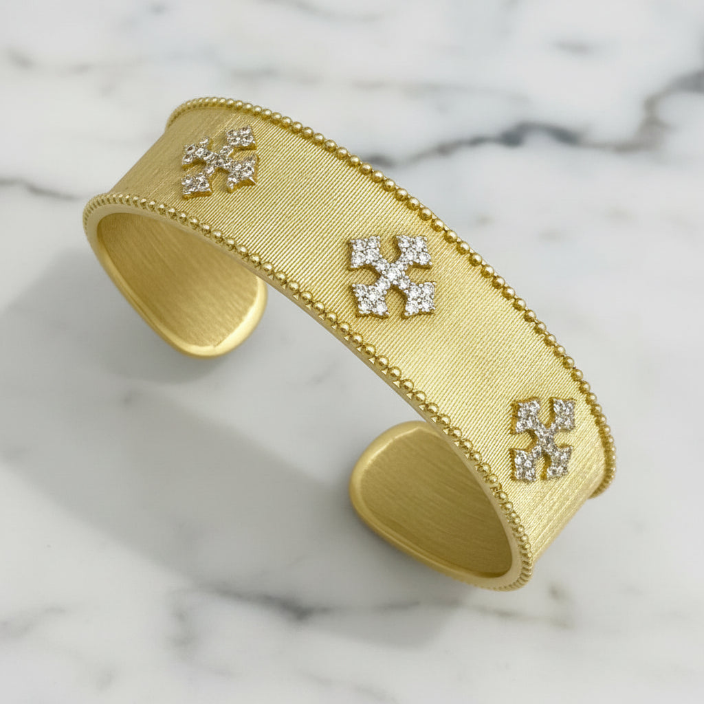 Lorena gold cuff bracelet with pave crosses, featuring intricate cross details and a stylish, modern design.