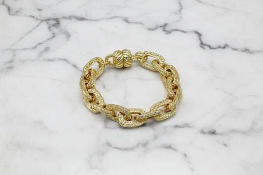 Lorena chunky gold link magnet bracelet with bold, interconnected links on a neutral background