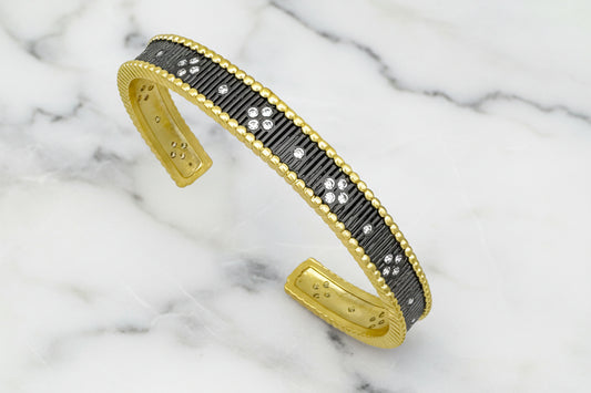 Lorena gold cuff bracelet with hematite stones and cubic zirconia accents, stylish and elegant jewelry accessory.
