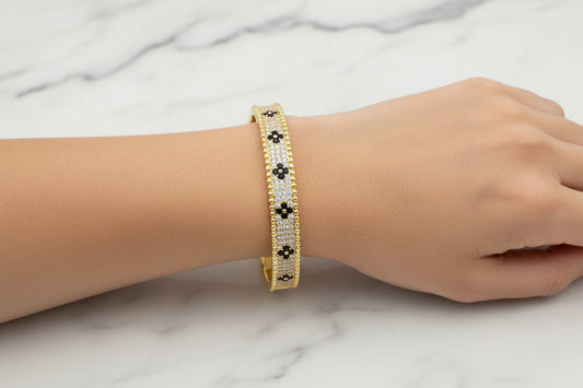 Lorena gold CZ bracelet featuring black CZ flower accents, showcasing elegant jewelry design and intricate craftsmanship.