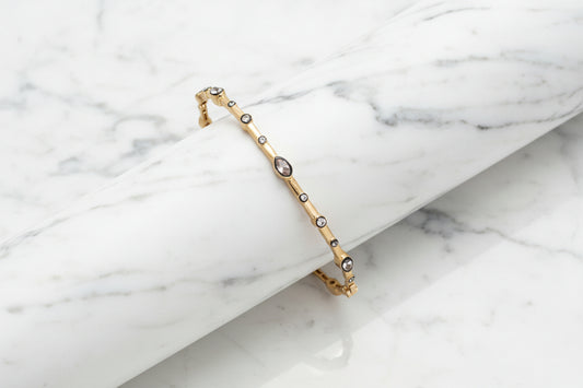 Lorena gold hematite CZ bangle bracelet with marquise-shaped stones, showcasing elegant jewelry design and sparkling gemstone accents.