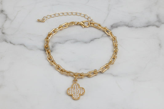Lorena gold link bracelet with sparkling CZ clover charm, stylish jewelry accessory featuring intricate chain links.