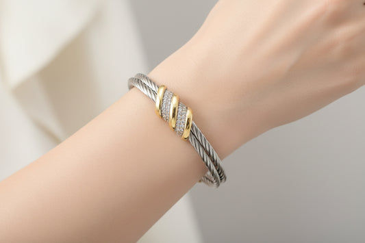 Lorena two-tone cable cuff bracelet with CZ swirl design, featuring a stylish, modern jewelry piece with sparkling accents.