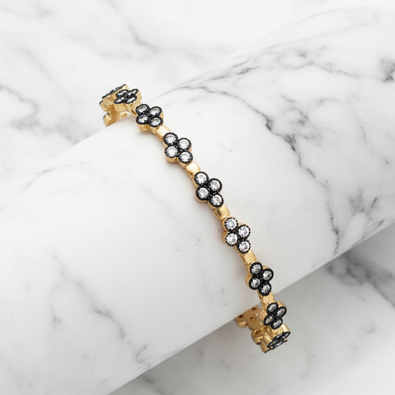 Gold hem CZ flower bangle bracelet by Lorena with sparkling flower design and CZ accents, stylish jewelry accessory.