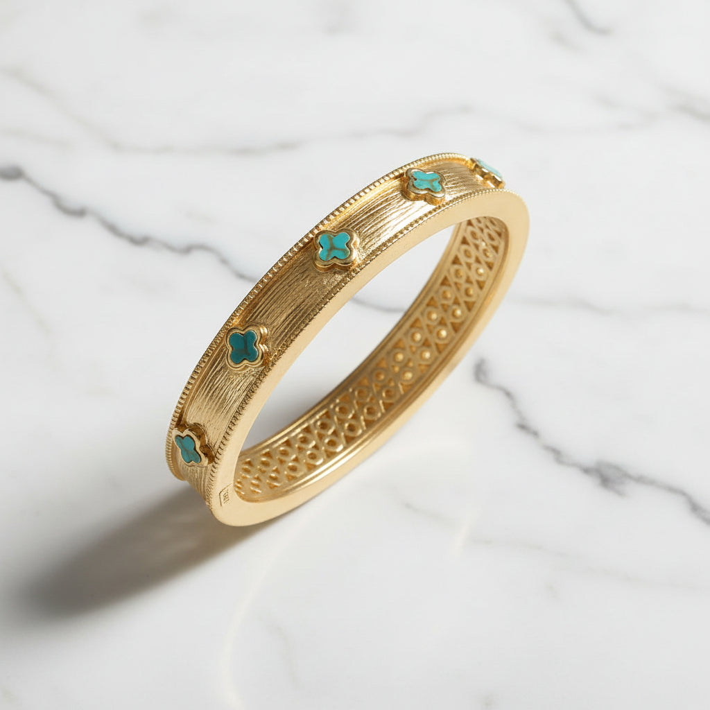 Lorena brushed gold TQ clover bracelet featuring a sleek, modern design with a textured gold finish and clover accents.