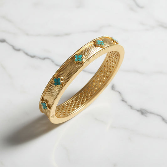 Lorena brushed gold TQ clover bracelet featuring a sleek, modern design with a textured gold finish and clover accents.
