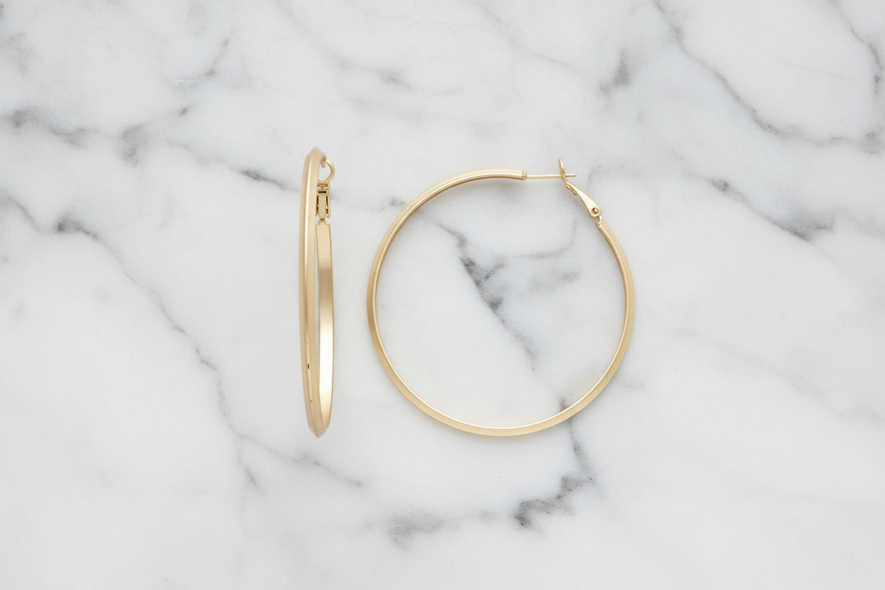 Lorena 2.25-inch gold hoop earring with a smooth, shiny finish, showcasing a stylish and classic jewelry accessory.