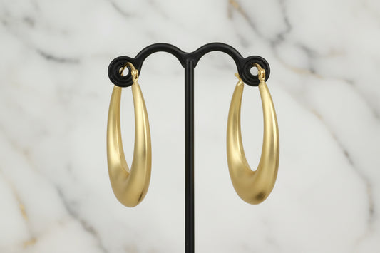 Lorena brushed gold oval hoop earring showcasing a sleek, modern design with a polished finish and secure clasp.