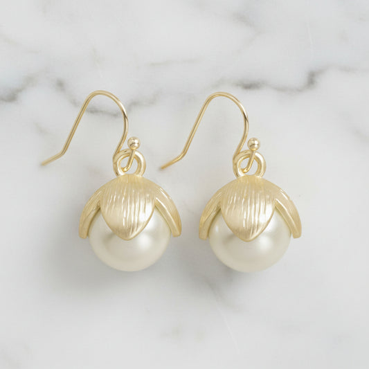 Lorena gold and pearl drop earring with elegant design, featuring a pearl pendant hanging from a sleek gold setting.