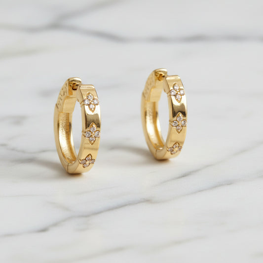 Gold huggie hoop earring with cubic zirconia stones by Lorena, featuring a sleek design and sparkling accents.