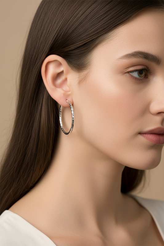 Lorena 1.5-inch shiny hammered hoop earring showcasing a smooth, reflective surface and classic hoop design.