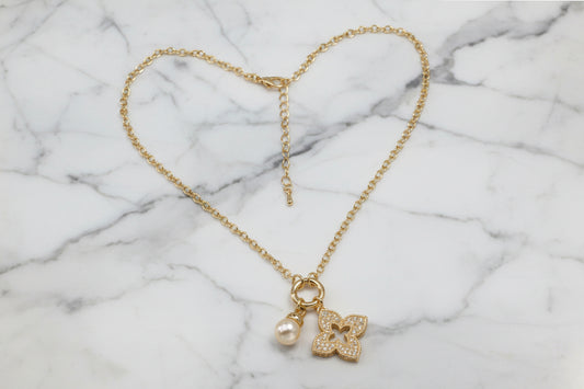 Lorena gold chain necklace with charming clover and pearl pendant charms, showcasing elegant jewelry design.