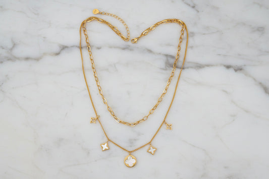 Gold Lorena 2-chain MOP charm necklace with intricate white oyster shell charms on a stylish chain.