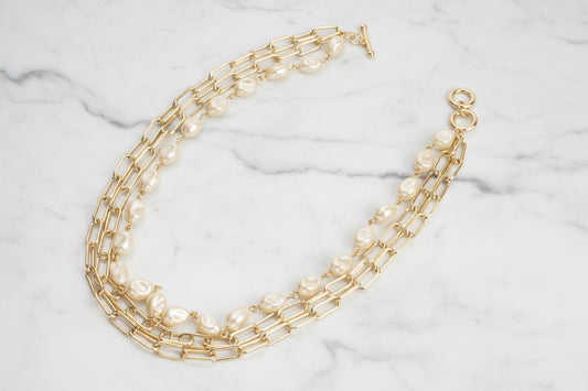 Gold 3-strand paper clip necklace with pearls by Lorena, featuring layered design and elegant jewelry details.