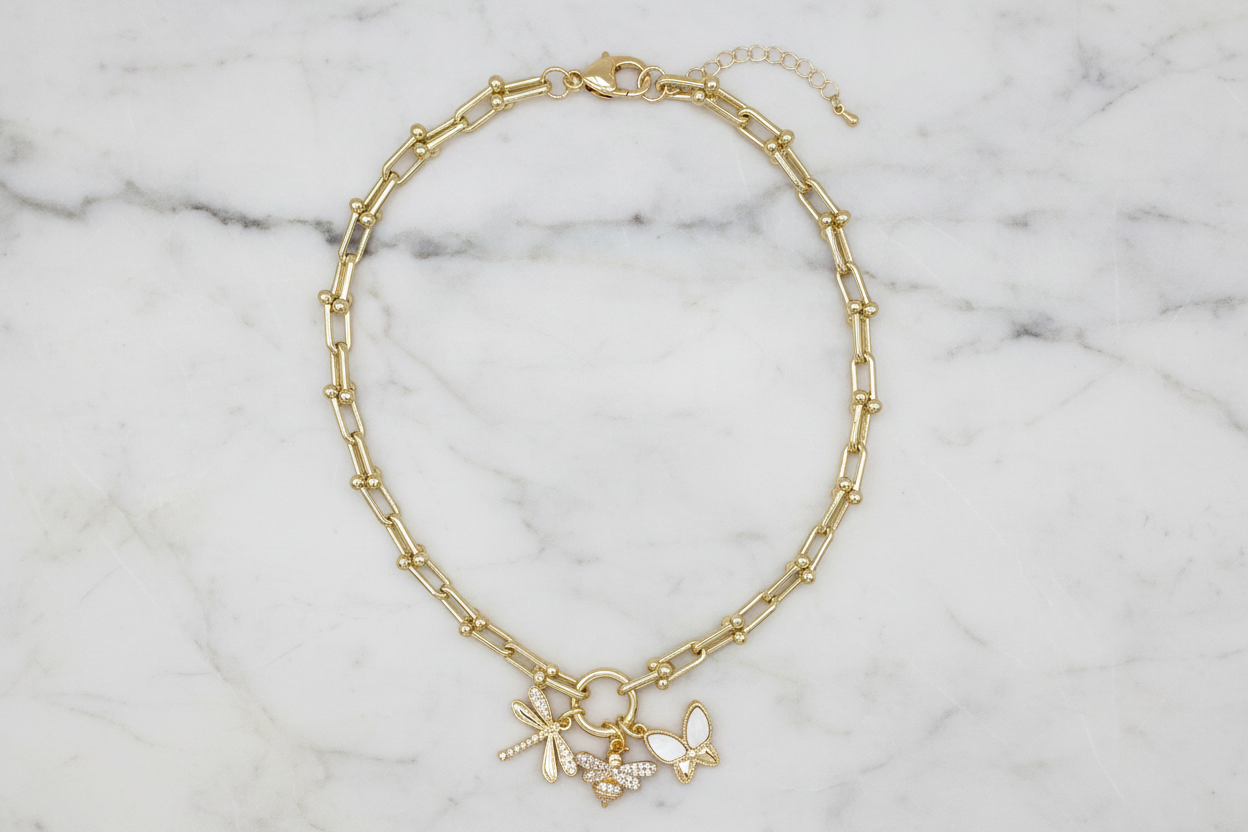 Lorena gold chain necklace featuring playful bug charms, stylish jewelry accessory for everyday wear and unique fashion statements.