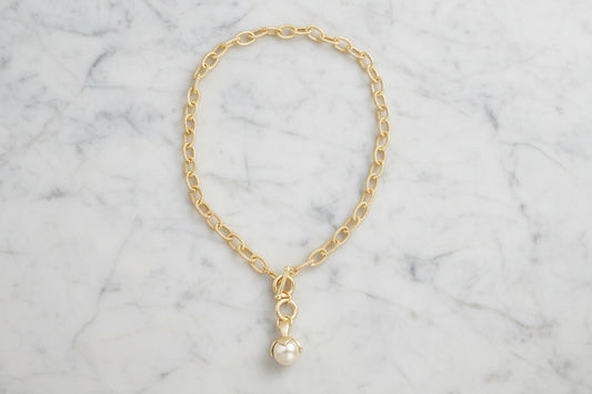 Lorena gold chain necklace with a pearl drop toggle closure, featuring a delicate and elegant jewelry design.