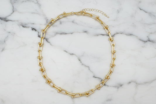 Lorena gold link chain necklace, 16-inch length, showcasing shiny interconnected links on a neutral background.