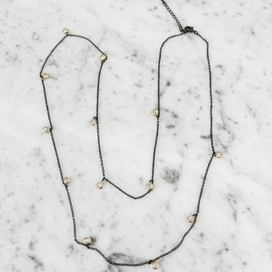Lorena hematite necklace with round cubic zirconia accents, 36-inch long, featuring sleek black metallic beads and sparkling stones.