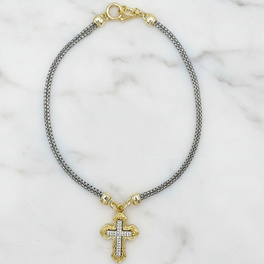 Lorena two-tone double chain necklace with cross pendant, featuring layered gold and silver chains, close-up view.