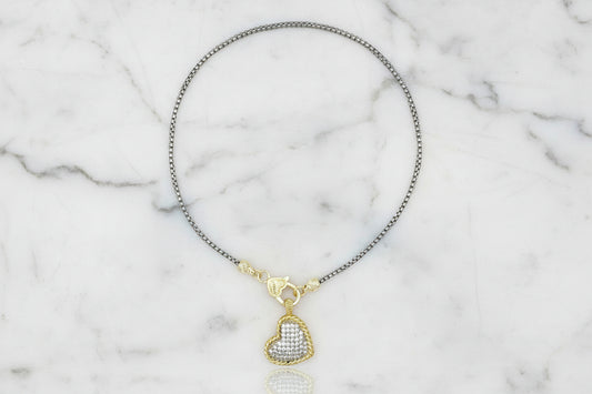 Lorena two-tone necklace with pave heart pendant, showcasing a stylish jewelry piece with layered metal and sparkling embellishments.