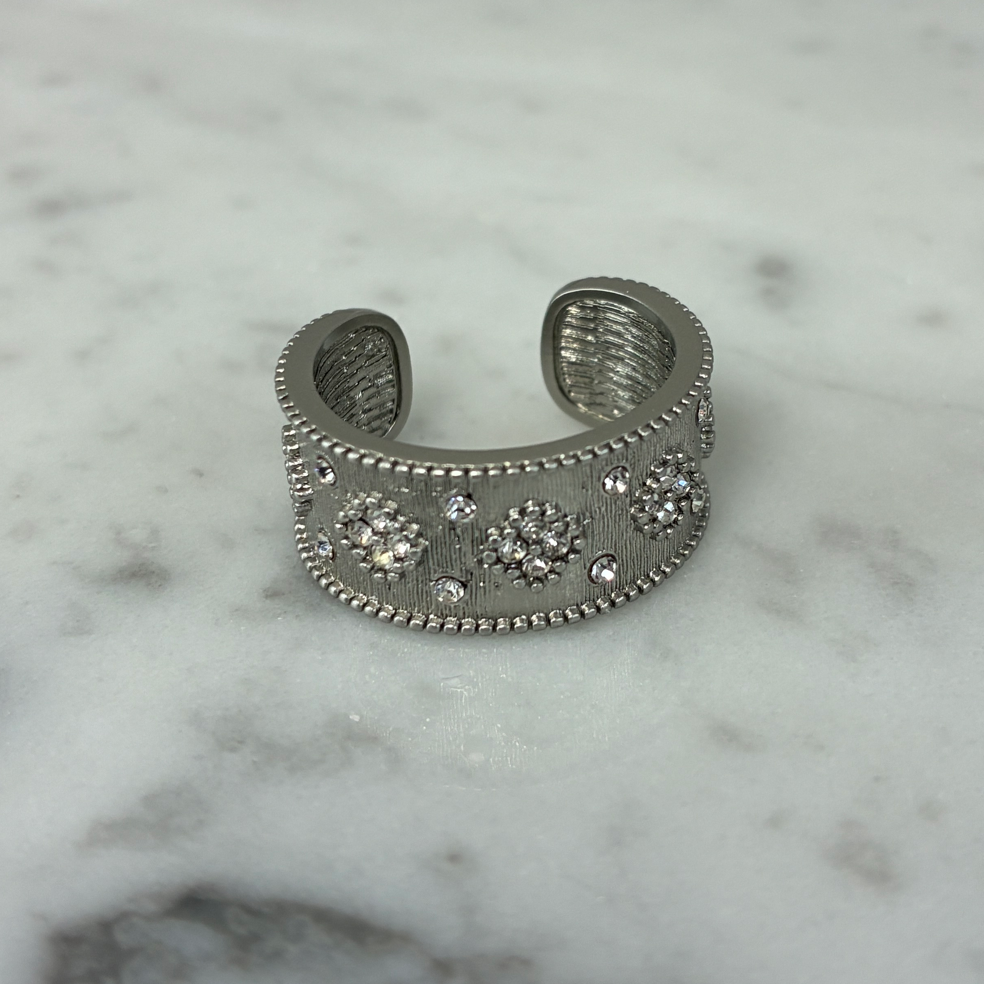 Marcony brushed wide band ring with sparkling cubic zirconia stones, showcasing a stylish and modern jewelry design.